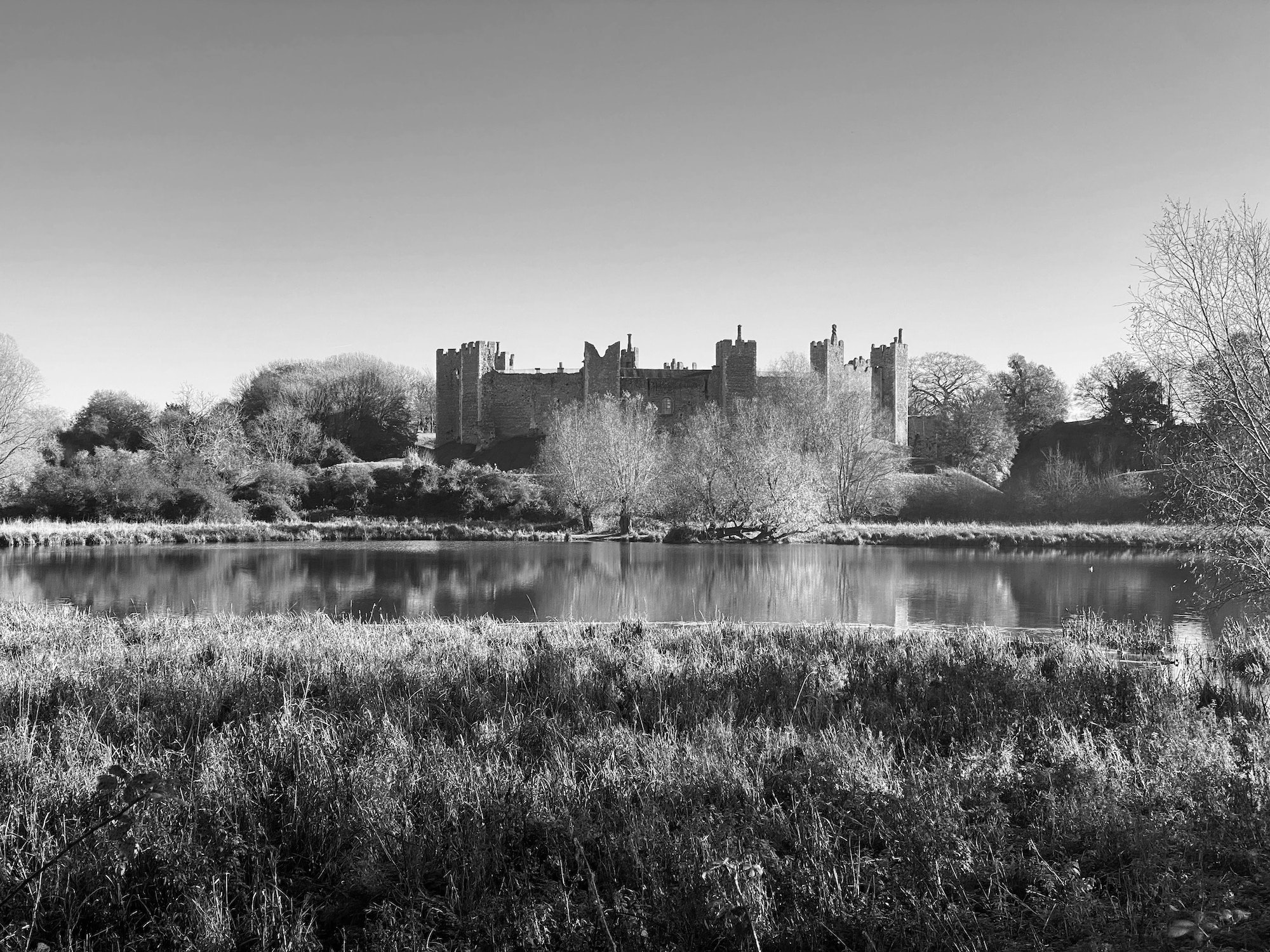 Grayscale shot of the old Framlingham Castle in the United Kingdom under a clear sky